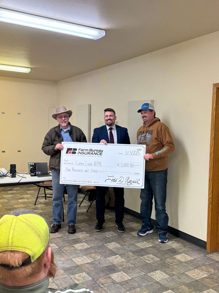 Volunteers from the Camas Creek RFPA accept a $5,000 donation from Dana May, Director of Customer Experience and Marketing at Farm Bureau Insurance Company of Idaho.