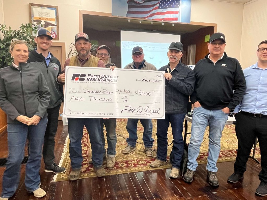 Farm Bureau Insurance Company of Idaho agents Nolan Stouder and Garren Taylor present a $5,000 check to the Shoshone Basin RFPA during a volunteer training session.