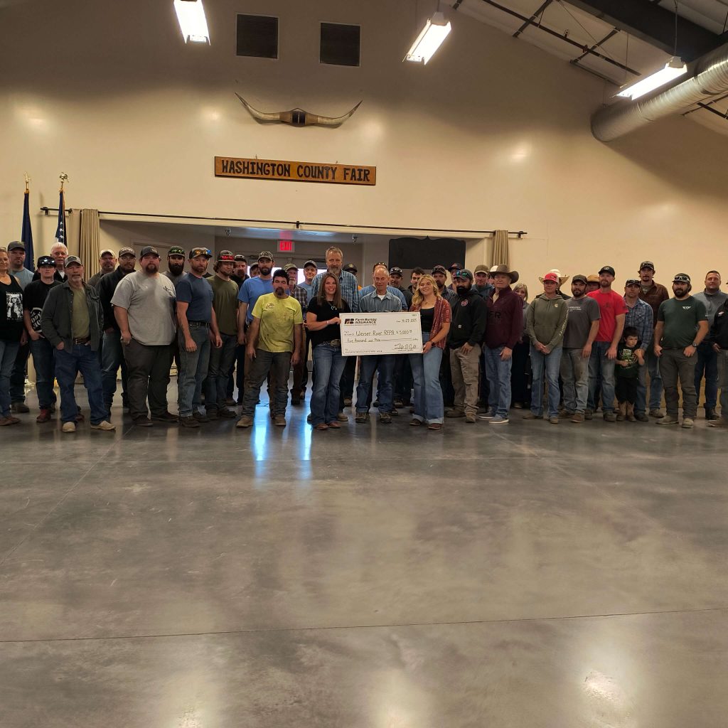 Farm Bureau Insurance Company of Idaho agent Dusty Bryant presents a $5,000 check to volunteers from the Weiser River RFPA.