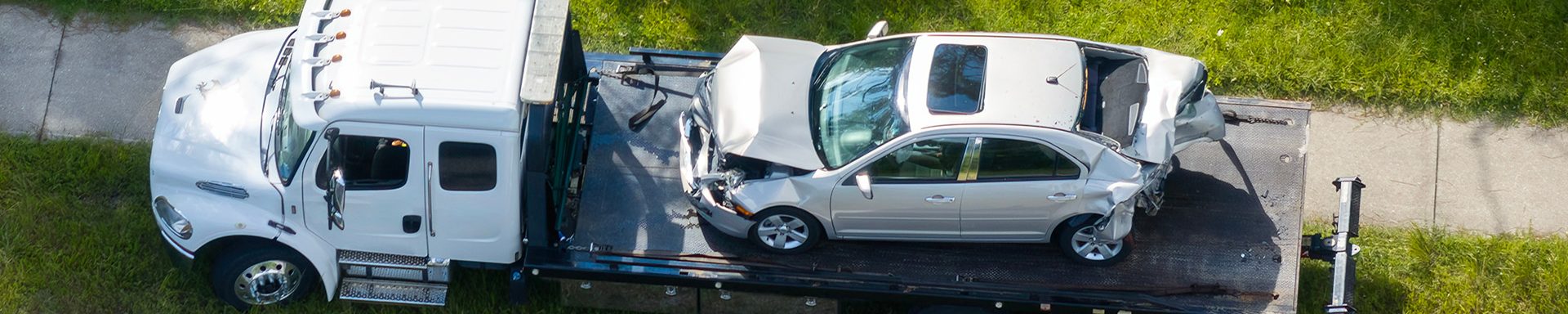 Car crash site with tow truck loading destroyed vehicle